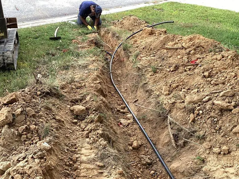 Head's Plumbing install of a new underground water line through an excavated trench.